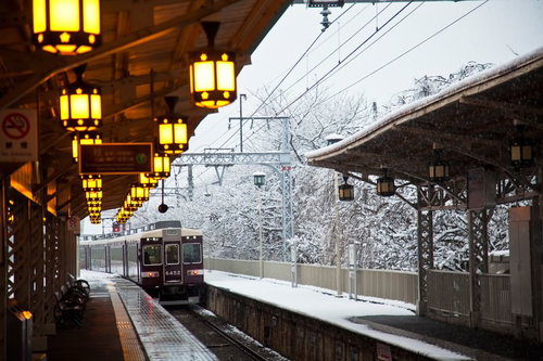 雪に覆われた駅ホームを通過する電車
