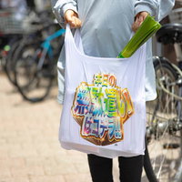 スーパーで長ネギを買った後、エコバッグを持って街中を歩くの写真