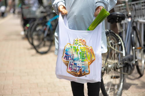 スーパーで長ネギを買った後、エコバッグを持って街中を歩く