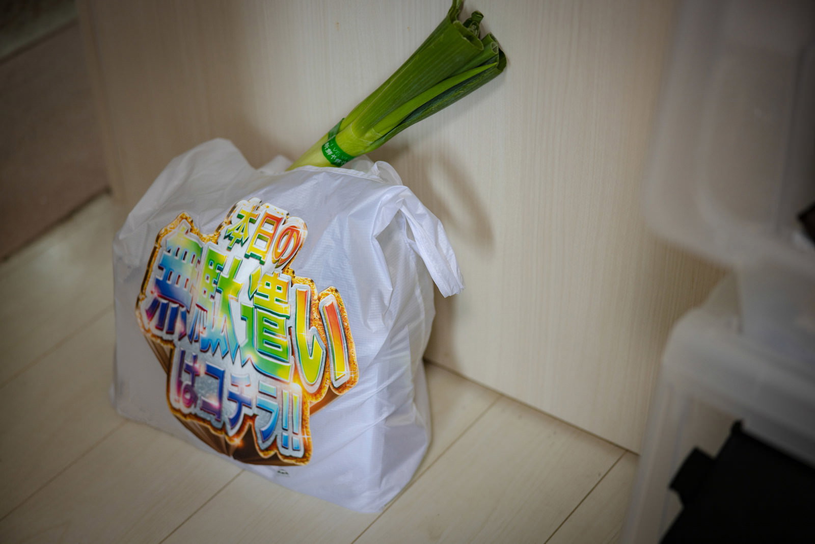 エコバッグに入った野菜や食料品が白い床に置かれている
