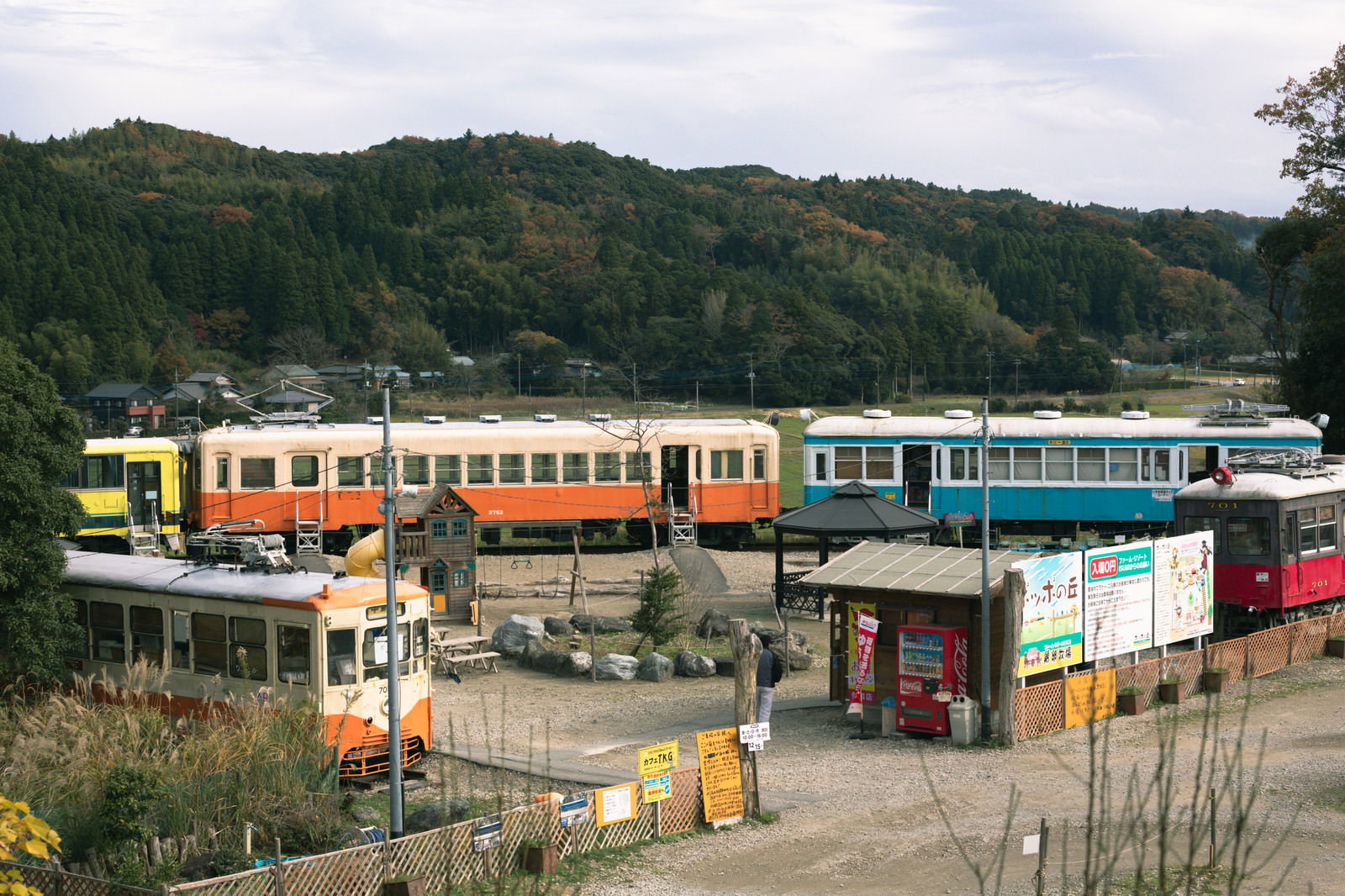 ぽっぽの丘に展示されたオレンジと青の電車と山の風景