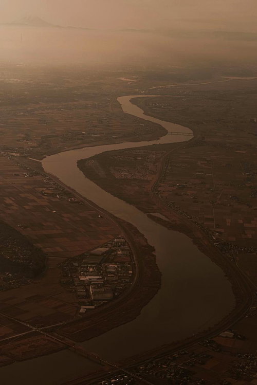 夕暮れに染まる富士山麓の広大な平野を蛇行しながら流れる大河