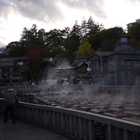 草津温泉の湯畑から立ち上る湯気と温泉街の町並みの写真