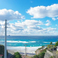 神津島から見える爽やかな青空とエメラルドグリーンの波の写真