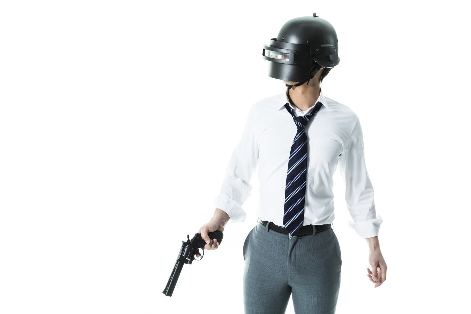 黒いヘルメットをかぶりスーツを着た男性が拳銃を構えている［モデル：大川竜弥］