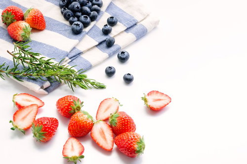 カットしたみずみずしいイチゴとブルーベリー