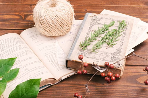 アンティークデスクの上に広げた古い洋書と雑貨