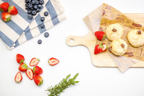 木製ボードに盛られたスコーンとブルーベリー、苺のフルーツ