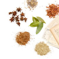 ハーブや粉末の漢方調味料と古書、料理レシピの写真