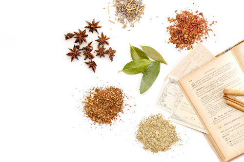 ハーブや粉末の漢方調味料と古書、料理レシピ