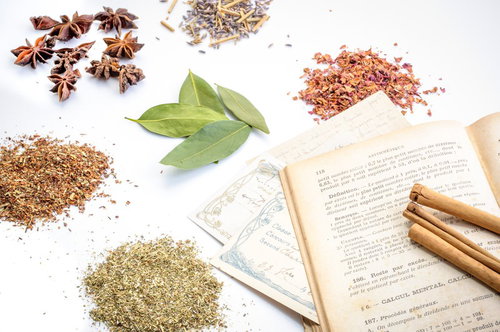 乾燥ハーブと粉末調味料に囲まれた古い洋書