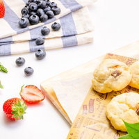 朝食テーブルに並ぶ苺とブルーベリー、スコーンとパンの写真