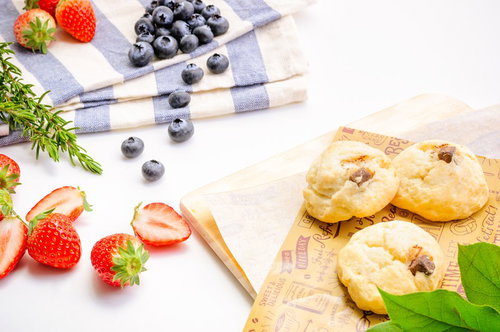 朝食テーブルに並ぶ苺とブルーベリー、スコーンとパン