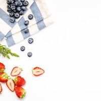 鮮やかな苺とブルーベリーとスコーンのフラットレイの写真