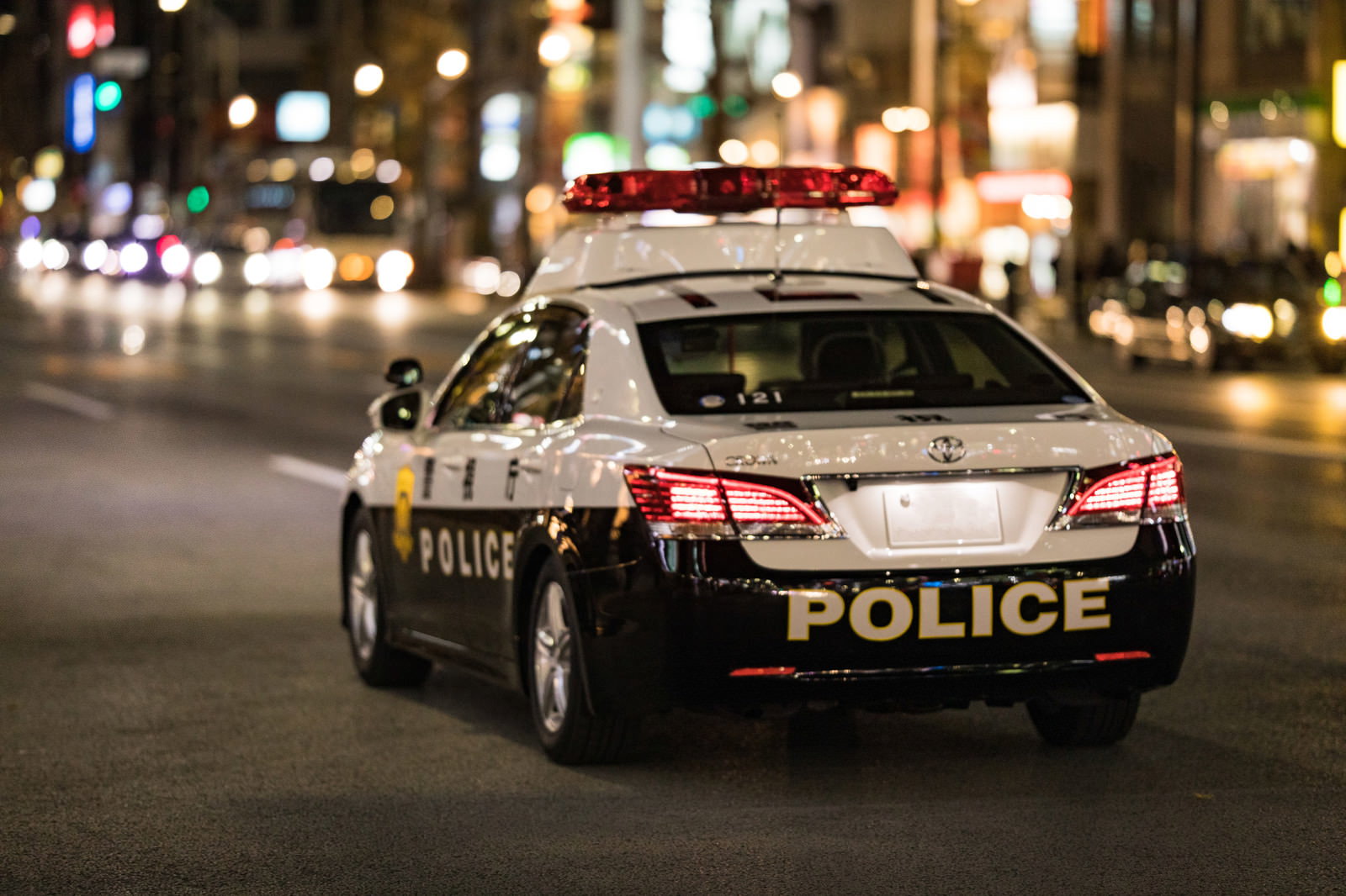 Rear View of a Police Car Patrolling a City Street at Night Free Stock ...