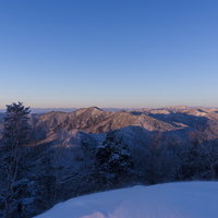 朝日が当たる奥秩父の雪山、雲取山を中心とした山々の写真