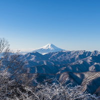 雲取山から見た朝日に輝く雪の富士山と冬の山並みの写真