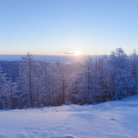 登りゆく朝日と雲取山の霧氷に輝く雪山の冬景色の写真
