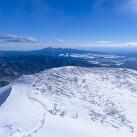 雪に覆われた上州武尊山の稜線へと続く足跡の写真