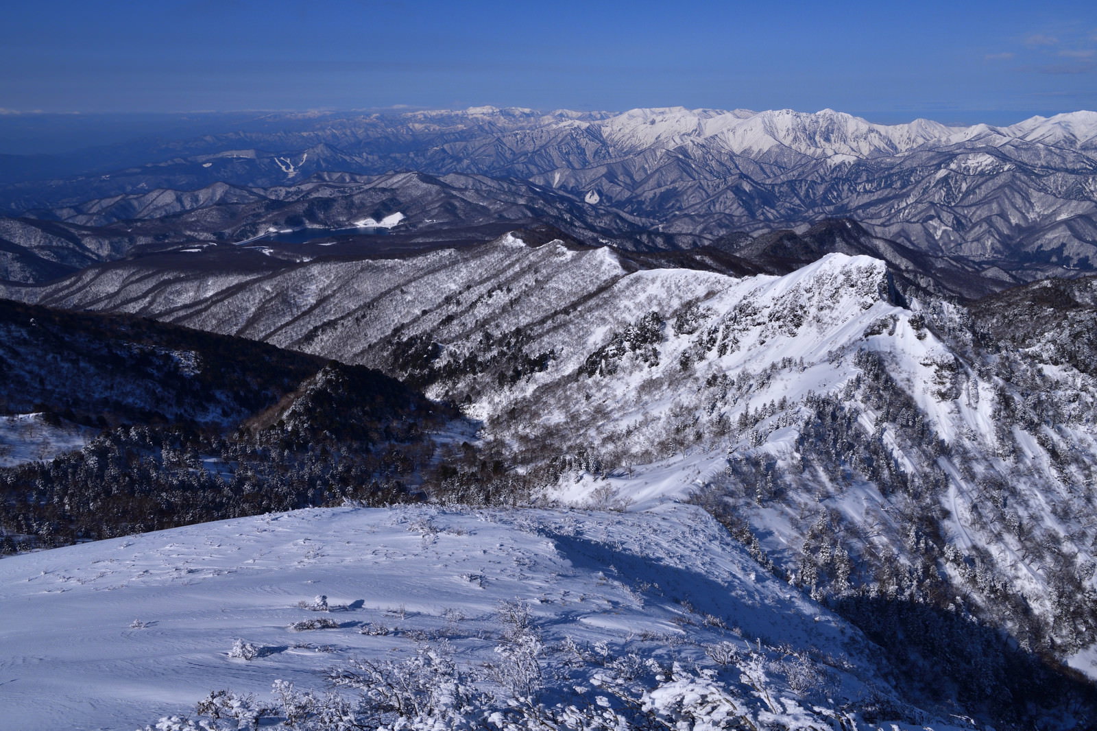 青空の下に雪化粧した上州武尊山をはじめとする上信越の山々