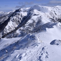 厳冬の上州武尊山、雪に覆われた山稜と岩肌の写真