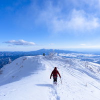 雪原を走る赤い登山者、積雪の上州武尊山、冬の日本百名山の写真