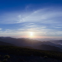ご来光で青く染まる空と山々のシルエット（乗鞍岳）の写真