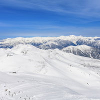 乗鞍岳から眺める中央アルプスの雪に覆われた山々の写真