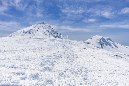 雪に埋もれた指導標と乗鞍岳の山頂の冬景色