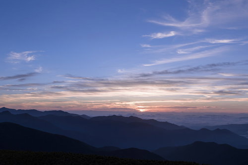 日の出を迎える乗鞍岳の朝焼けの空と山並みのシルエット