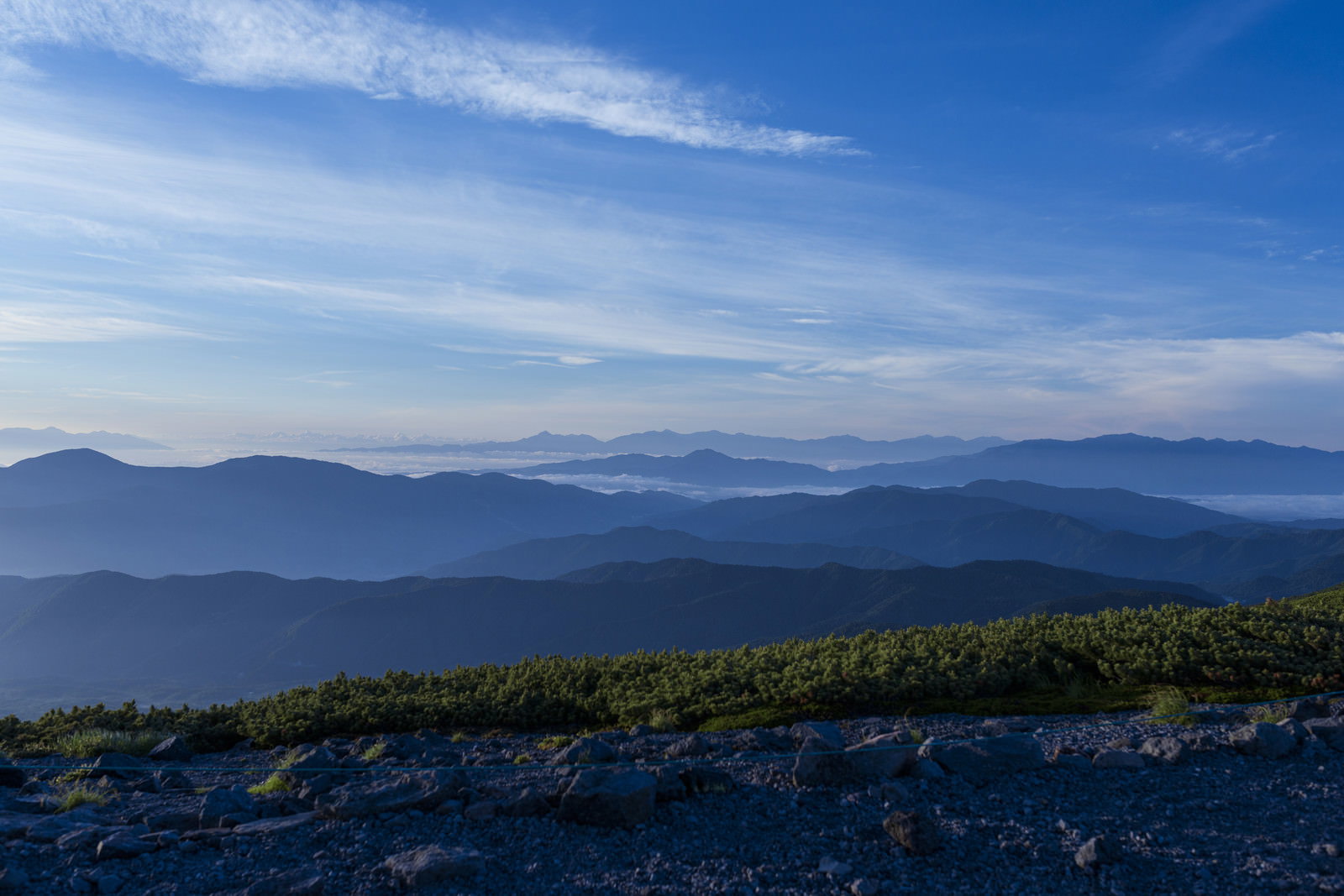 乗鞍岳から見た青空と雲が広がる山々の連なる風景