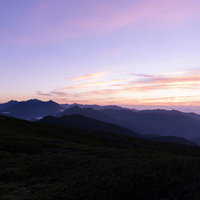 紫色に染まる朝焼けの空と乗鞍岳から見るアルプスの山並みの写真