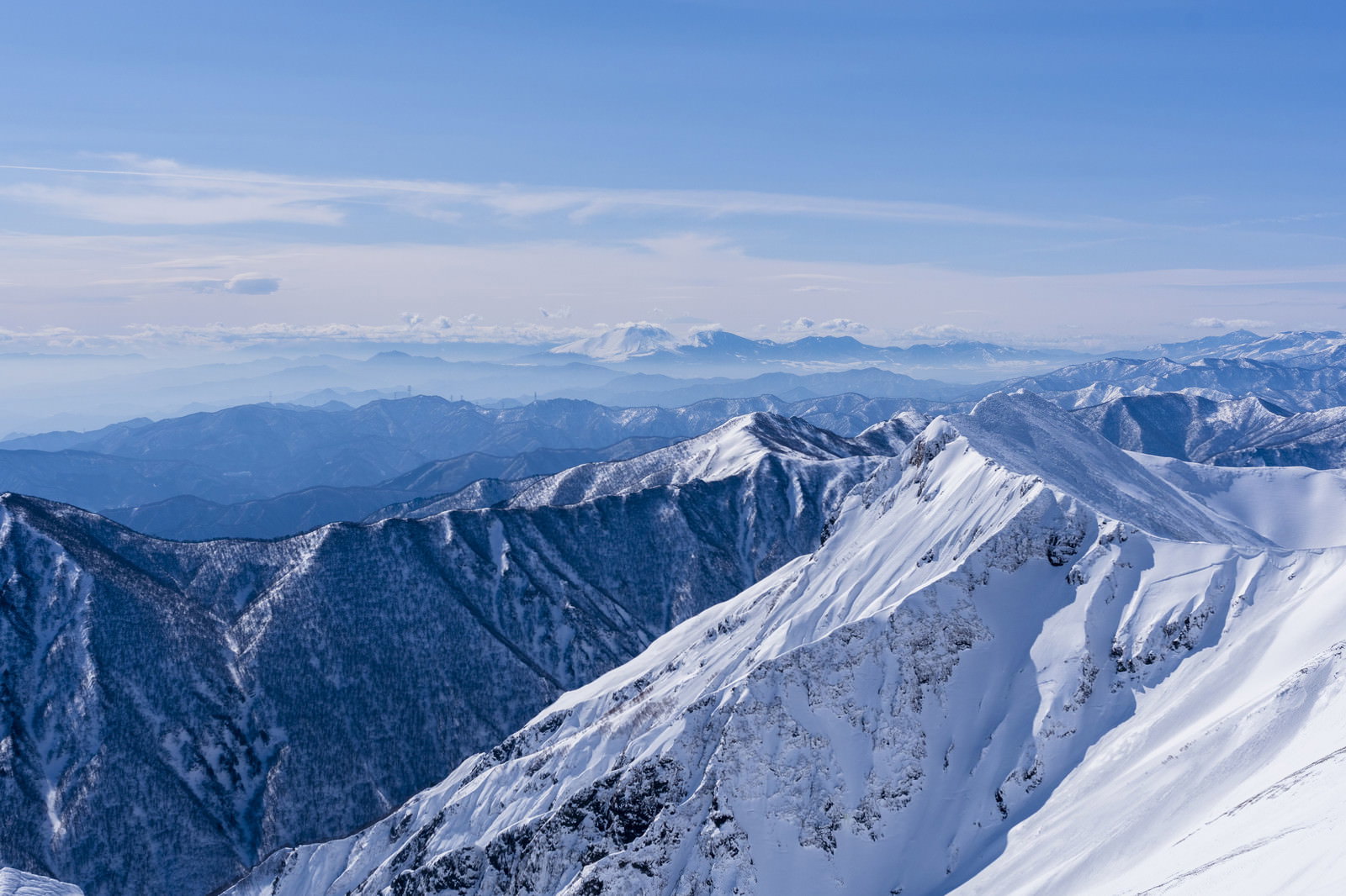 雪に覆われた谷川の山々と浅間山の山岳風景