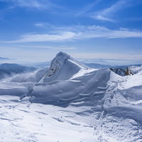 雪化粧した谷川岳トマノ耳を眺める登山者の冬景色の写真