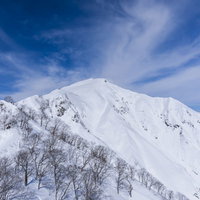 雪化粧した谷川岳の山頂を見つめる冬山の雄大な景観の写真