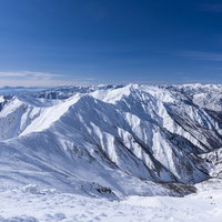 豪雪に覆われた谷川岳主脈の冬山景観と雪稜の全景の写真