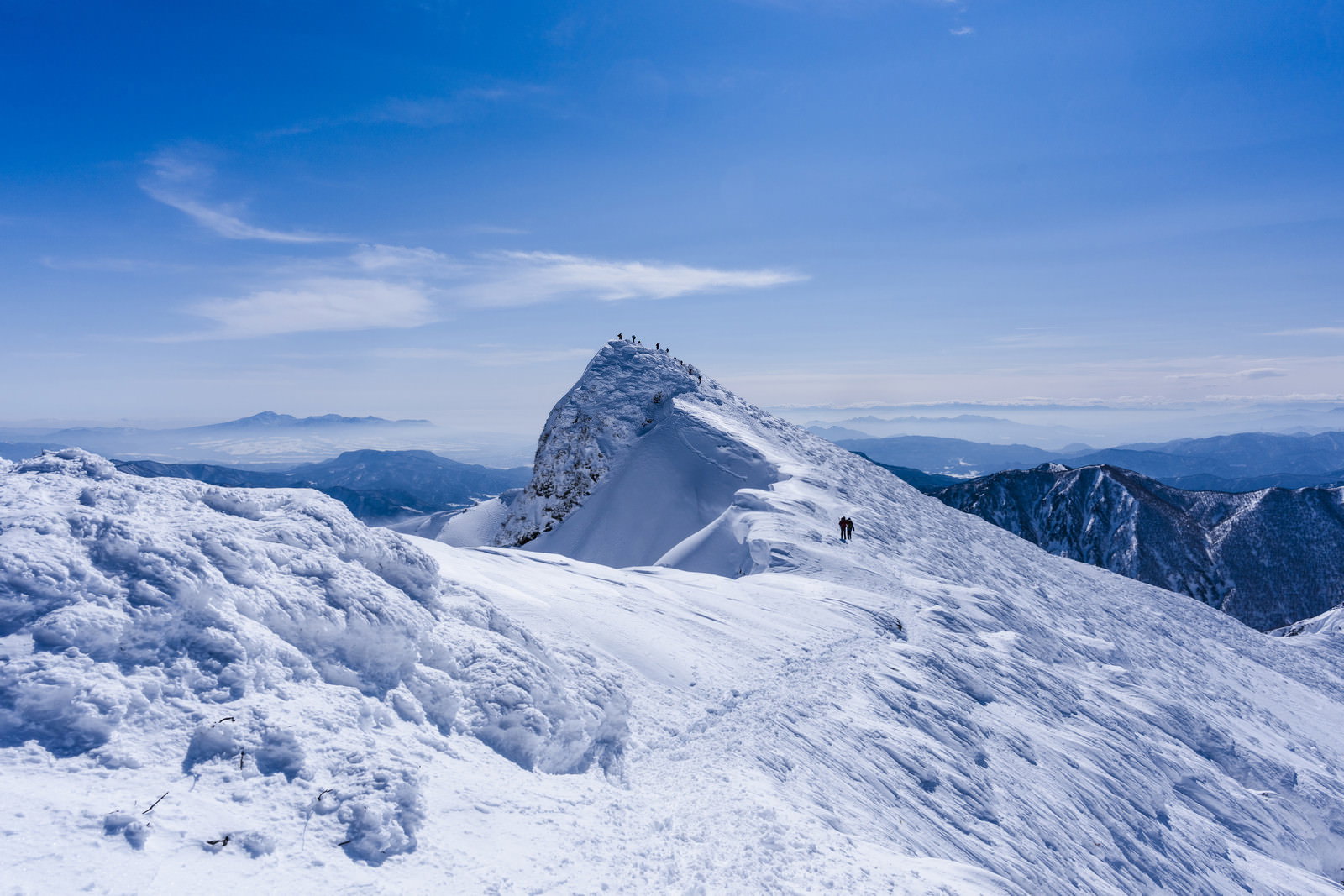 雪に覆われた谷川岳のトマの耳と青空が広がる山岳風景