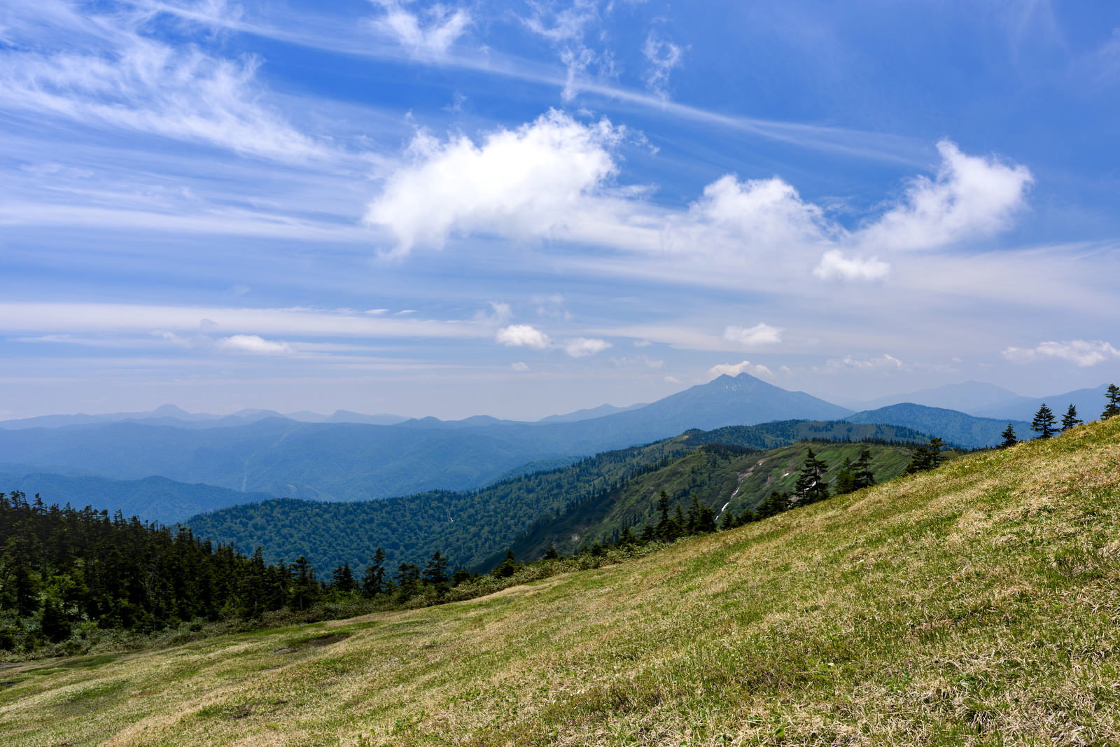 会津駒ヶ岳の草原稜線から眺める燧ヶ岳と青空の風景