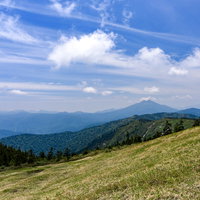 会津駒ヶ岳の草原稜線から眺める燧ヶ岳と山々の風景の写真