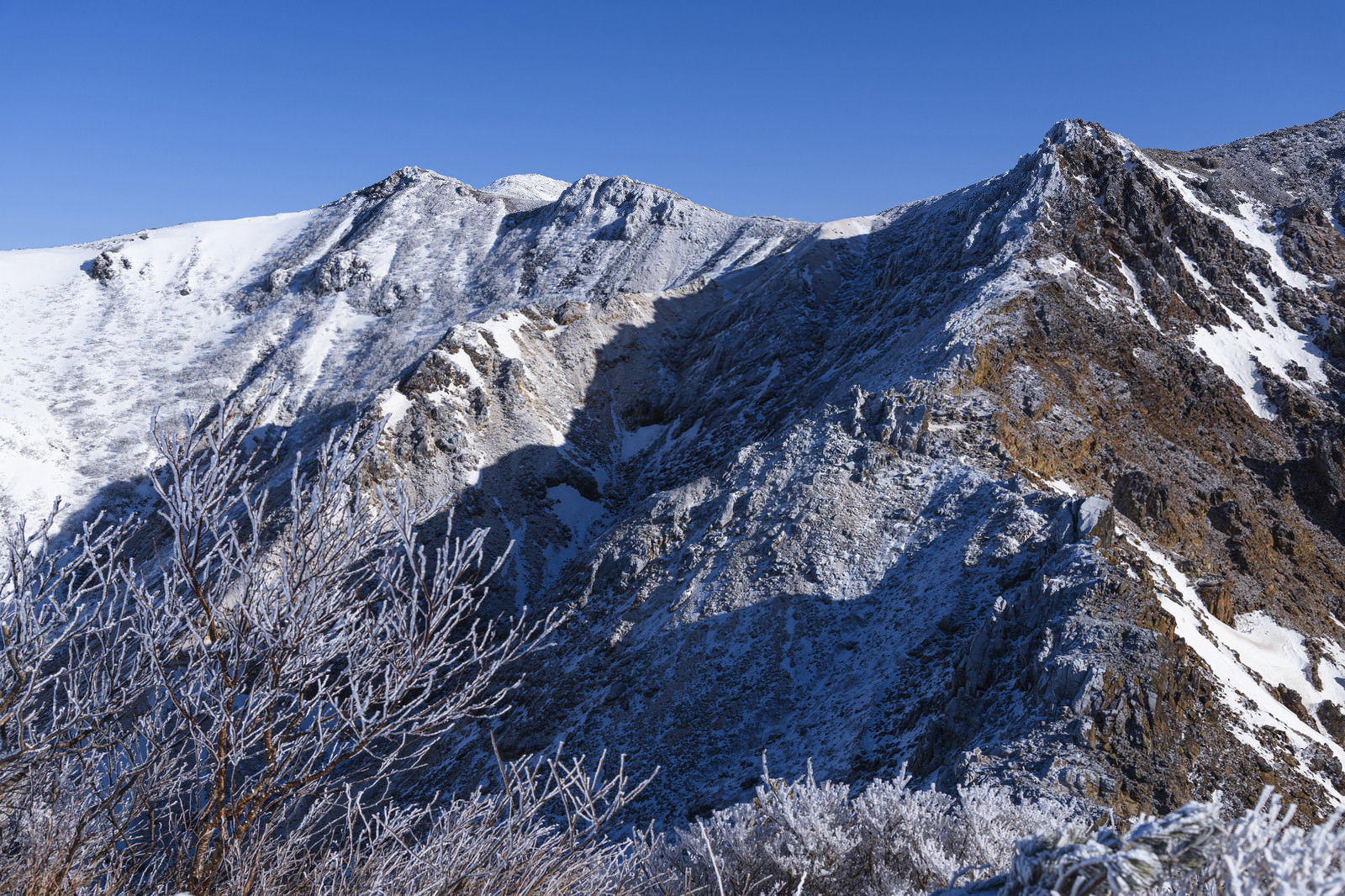 雪に覆われた那須岳の山並みと青空