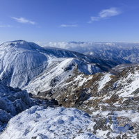 冬の那須岳に雪化粧した成層火山の荒々しい山稜の写真