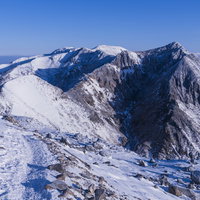 凍り付いた那須朝日岳の山頂と周囲の雪山景色の写真