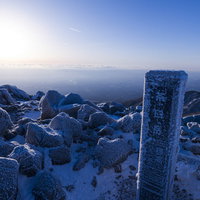 凍り付いた那須茶臼岳山頂の山頂標と冬景色の写真