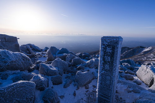 凍り付いた那須茶臼岳山頂の山頂標と冬景色