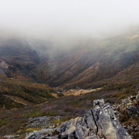 分厚い雲の下の紅葉（那須岳）の写真