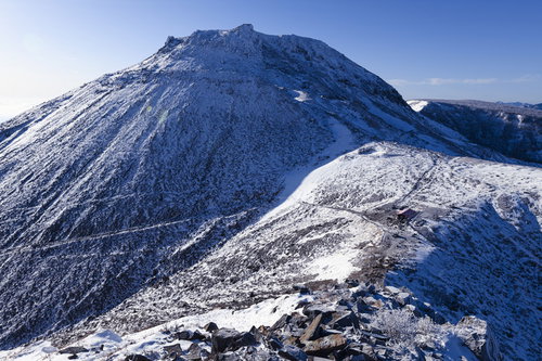 剣ヶ峰山頂から見る雪化粧の那須茶臼岳と冬の山肌