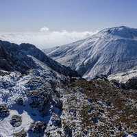 吹き付ける雪の痕跡と雪化粧した那須茶臼岳の写真