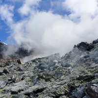 白い噴気に包まれる那須岳の成層火山登山道の写真