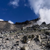 地獄のような地面と青空に立ち上る噴気（那須岳）の写真