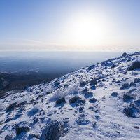 朝日が照り付ける那須茶臼岳の雪山斜面、冬の登山風景の写真